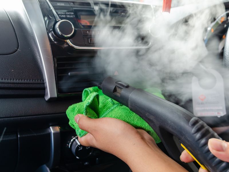 Dùng máy hút bụi mini và khăn sạch để vệ sinh cửa gió máy lạnh ô tô