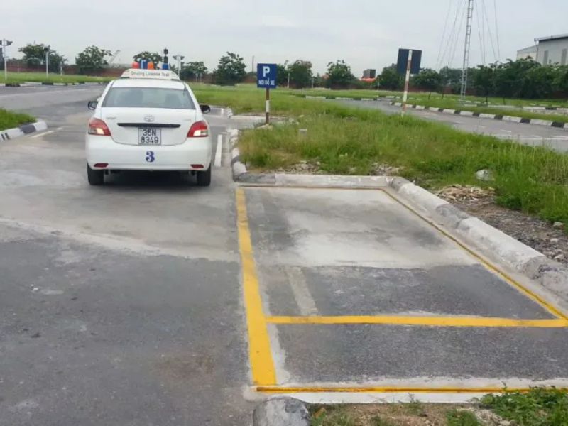 Lùi xe vào chuồng ngang, giữ xe song song và cách vạch giới hạn khoảng 30–40 cm