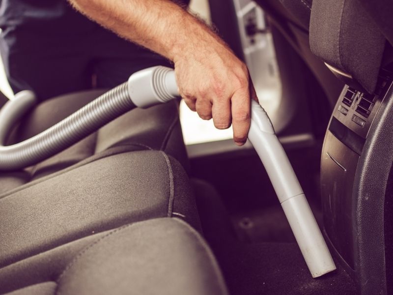 Sử dụng máy hút bụi để hút hết nước trong sàn xe ra ngoài