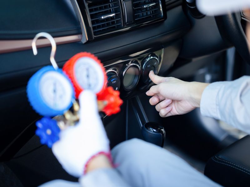 Kỹ thuật viên kết nối đồng hồ đo với điều hòa để đo áp suất gas lạnh