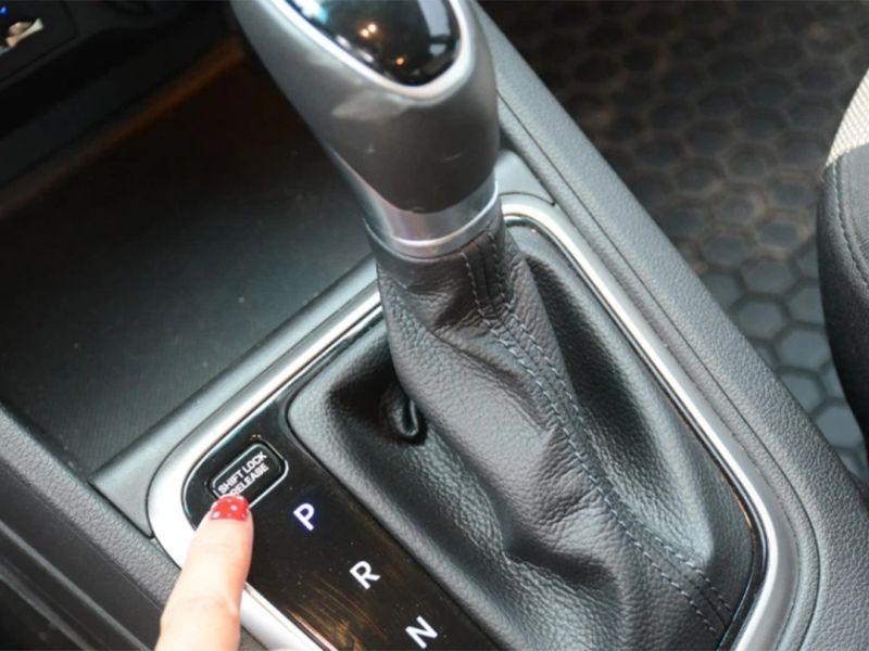 Dùng nút Shift Lock đồng thời đạp phanh để mở cơ cấu số