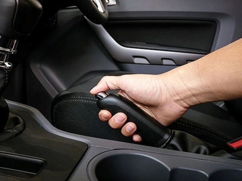 Kéo hết cần phanh tay rồi hạ dứt khoát để nhả lại phanh